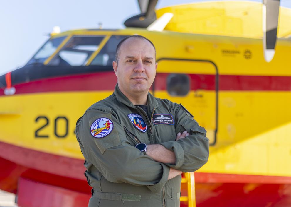 Stefanos Karpetis standing in front of a firefighting plane