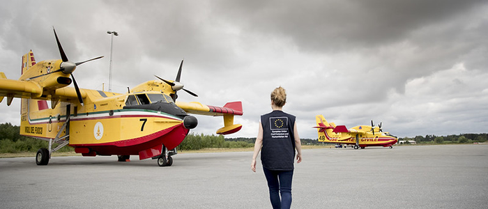 Aid worker amids firefighting planes.