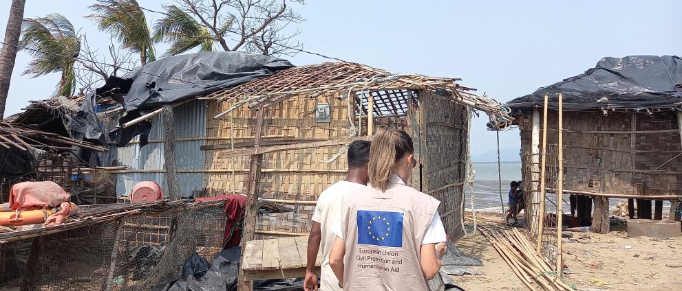 Aid workers walking inbetween damaged houses