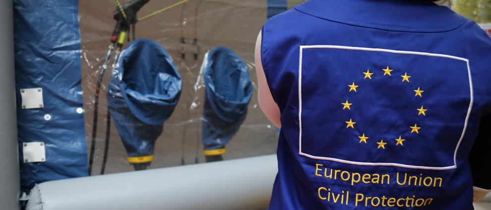 A vest with the EU flag seen from the back, in the background an airthight tent.