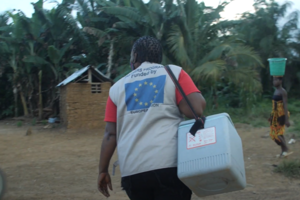 Aid worker walking towards a hut