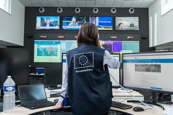 EU staff posing in the Emergency Response Coordination Centre with an EU vest