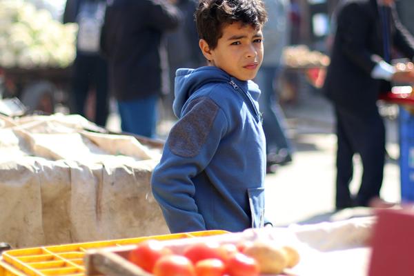 Boy in front of a grocery stall