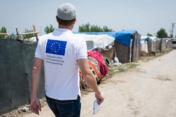 Aid worker walking on a road in the refugee settlement
