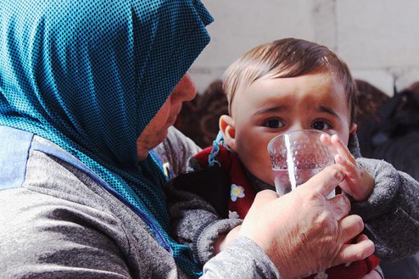 Abu Reza’s oldest daughter is helping her child with a glass of water.