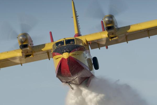 A yellow firefighting plane dropping water