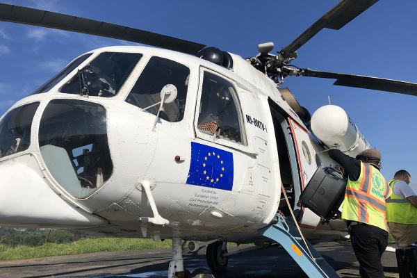 Partial view of a helicopter, the EU flag on one of the doors.