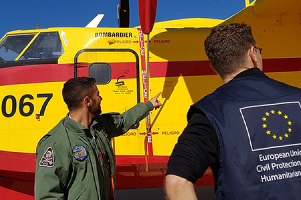 EU civil protection officer in front of a plane of the rescEU fleet