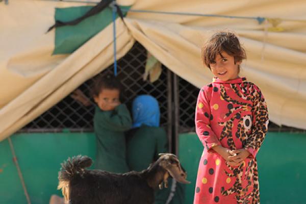 Some children in front of a shelter tent