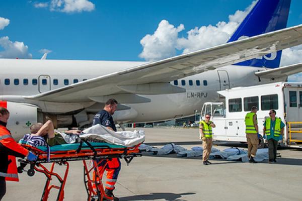 Patient on a stretcher being moved to an airplane