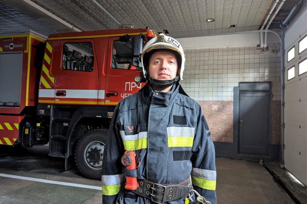 Andriy, a Ukranian firefighter, standing in front of a firefighting truck