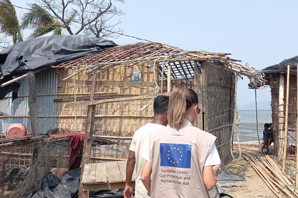 Aid workers walking inbetween damaged houses