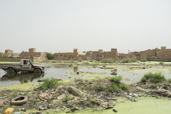 View of the outskirts of a city, a truck in flooded land.