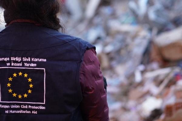 Person seen from the back, on the jacket is the EU flag with text.